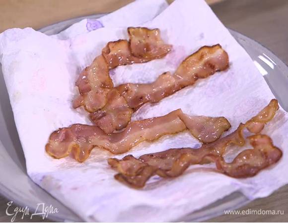 Разогреть в сковороде-гриль 1‒2 ч. ложки оливкового масла и обжаривать бекон до появления золотистой корочки, затем выложить на бумажное полотенце, чтобы удалить излишки жира.