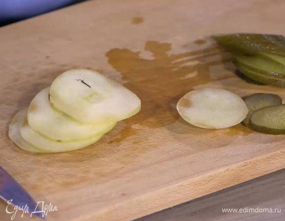 Маринованный огурец и моченое яблоко нарезать тонкими ломтиками.