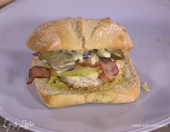 Оставшийся хлеб смазать майонезом, выложить ломтики огурца, обжаренный бекон и сложить половинки чиабатты вместе.
