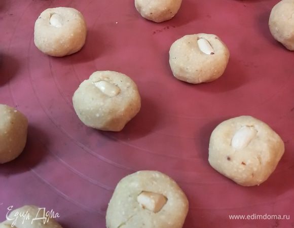 Из теста сделать маленькие шарики. В середину каждого положить по ядрышку арахиса. 