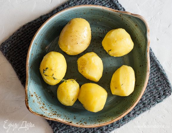 Картофель сложите на противень, сбрызните оливковым маслом, посолите, поперчите, посыпьте листочками молодого тимьяна. Перемешайте. 