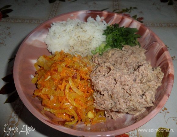 В чашку выкладываем отварной рис, рыбу, обжаренные овощи и зелень. Добавляем по вкусу соль и специи. Перемешиваем.