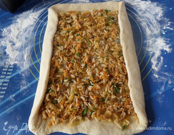 На рабочей поверхности раскатываем тесто в виде прямоугольника. Выкладываем начинку. Равномерно распределяем, не доходя до края 1 — 2 см. Края подворачиваем, чтобы начинка не вываливалась.