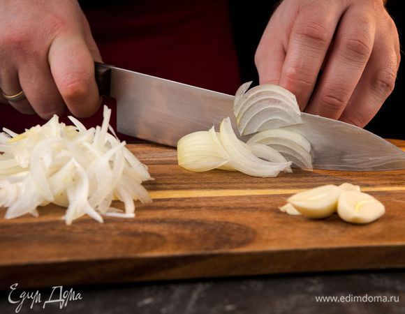 Духовку предварительно разогреть до 180°С. Лук почистить и нарезать полукольцами. Головку чеснока очистить от грубой верхней шкурки и разрезать вдоль пополам, затем одну половину тонко нарезать поперек.
