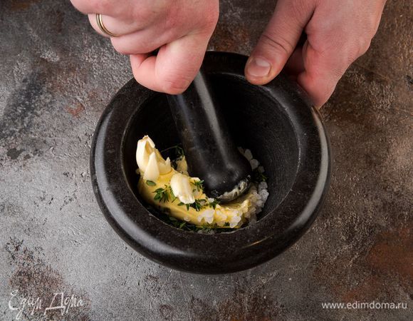 Приготовить пряное масло: оставшуюся половину чеснока нарезать так же, как и первую, растереть в ступке вместе с листьями тимьяна и щепоткой соли, добавить предварительно размягченное сливочное масло, поперчить и все перемешать.