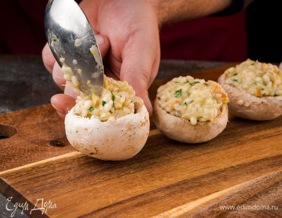 Добавить сулугуни с петрушкой в перловку, перемешать и начинить грибы, сверху намазать маслом.