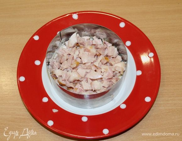 Мелко нарезать мясо куриного окорочка и выложить в форму.