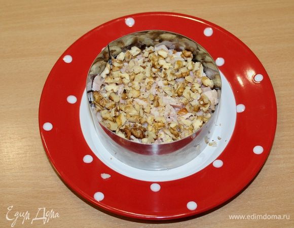 Третий слой — мелко порубленные грецкие орехи.