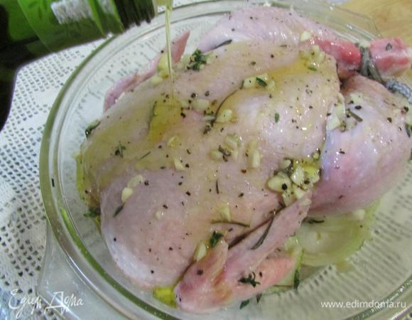 На лук выложить цыпленка (обязательно связать ножки). Затем залить цыпленка оставшимся маринадом, хорошо сбрызнуть оливковым маслом. 