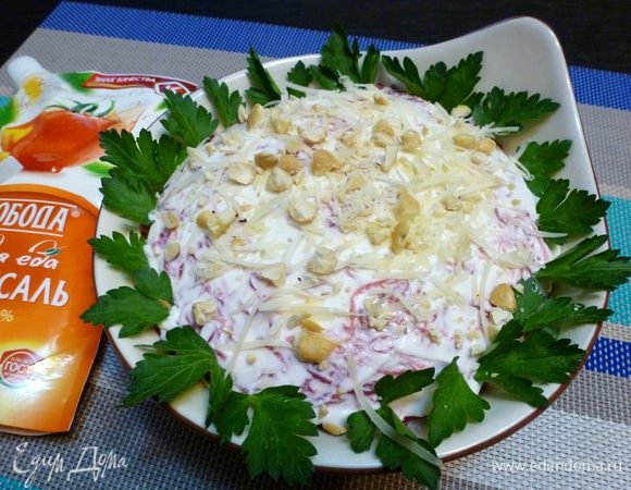 Верхний слой смазываем майонезом и украшаем стружкой сыра и орехами.