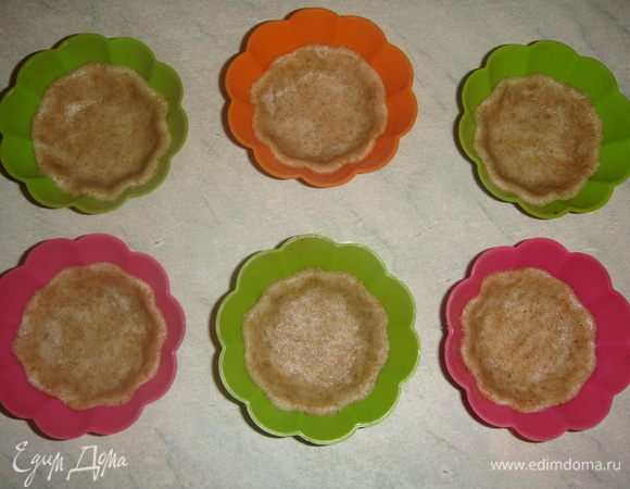 Выложить тесто в формочки и примять пальцами ко дну и стенкам. Дно наколоть вилкой.