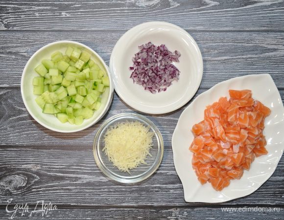 Огурец и семгу нарежьте средними кубиками, лук покрошите очень мелко, а пармезан натрите на мелкой терке.