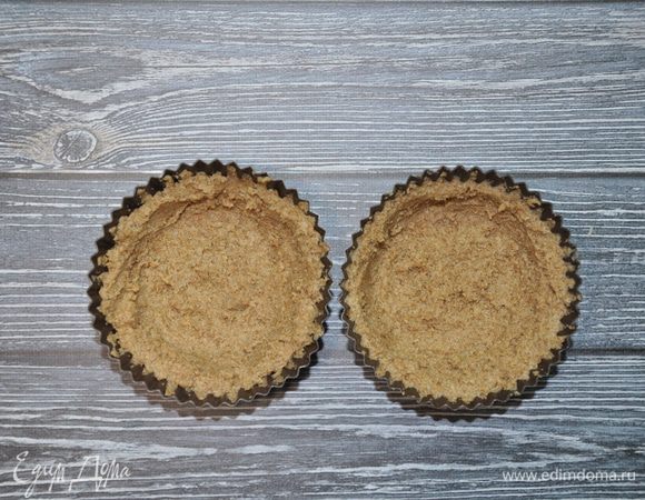 Выложите тесто в силиконовые формы слоем, толщиной примерно 0,5 см, и поставьте тарталетки в микроволновую печь на 2,5 минуты при мощности 800 Вт. Готовые тарталетки достаньте и дайте остыть.