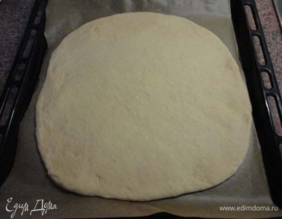 Подошедшее тесто разделить на две части, раскатать в два круга и выложить на противни, выстланные пекарской бумагой. Оставить расстаиваться на 30 минут.