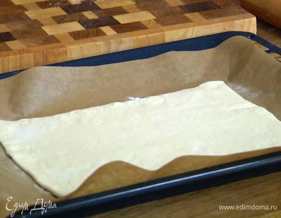 Рабочую поверхность посыпать мукой и слегка раскатать тесто, затем выложить на противень, выстеленный пищевой бумагой.