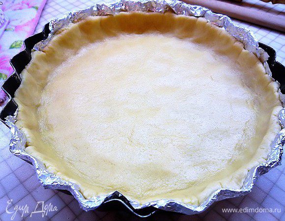 Форму для выпечки выстилаем фольгой или бумагой для выпечки, раскатываем по диаметру формы из теста круг, укладываем его в форму формируя высокие бортики. Выпекаем в заранее разогретой духовке при температуре 180°С в течении 15 минут.