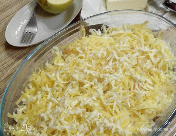 Следующий слой: сыр, ½ яблока (натереть на крупной тёрке) и сливочное масло (предварительно заморозить).