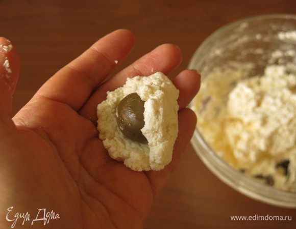 Оливки промываем от рассола, высушиваем на салфетке. Из феты делаем лепешку, кладем на нее оливку и формируем шарик.