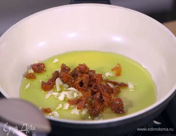 Разогреть в тяжелой сковороде оливковое масло и на медленном огне обжарить чеснок, вяленые помидоры и перец чили.