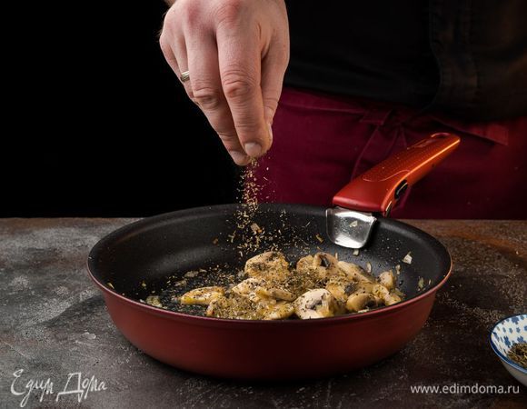 Разогреть в сковороде сливочное масло и 1 ст. ложку оливкового масла и обжарить лук с грибами до золотистого цвета, посыпать орегано, посолить, поперчить.