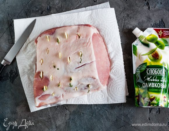 Затем нашпигуйте мясо резанными дольками чеснока и листочками тимьяна.