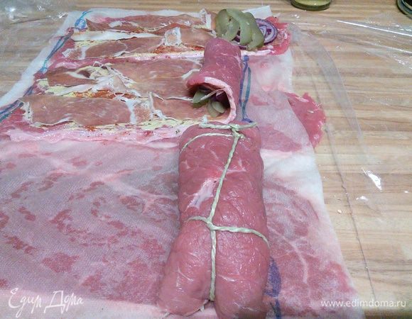 Закрутить мясо в рулеты, концы подгинать не обязательно, зато необходимо связать ролады пищевой ниткой. 