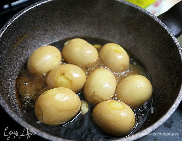 Уменьшить огонь и кипятить примерно 5 минут, постоянно переворачивая яйца, пока они не станут коричневыми, а соус не загустеет.