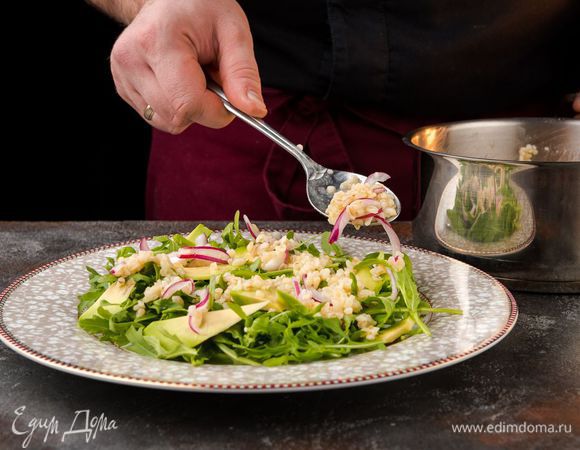 На блюдо выложить руколу, посолить, полить оставшимся лимонным соком и оливковым маслом, затем поперчить. Сверху разложить авокадо, булгур и зеленый горошек.
