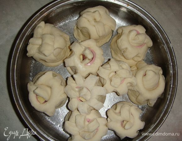 Круглую форму для запекания смазать маслом и поставить рулетики надрезами вверх. Дать постоять в тепле минут 20. Выпекать в разогретой до 180° духовке 30 минут до золотистого цвета.