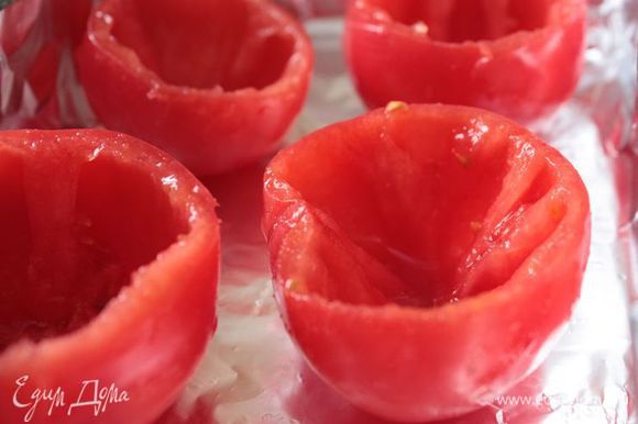 Для приготовления лучше всего подойдут спелые помидоры твердых сортов. Аккуратно срежьте шляпку и с помощи ложки удалите сок и мякоть. Выложите в форму и слегка сбрызните оливковым маслом.