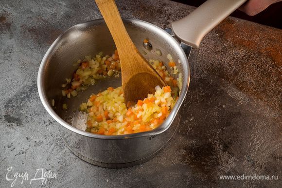 В кастрюле с толстым дном разогреть оливковое масло. Лук обжарить на среднем огне до полупрозрачного состояния, добавить морковь, чеснок. Обжарить все вместе в течение 3 минут, помешивая.