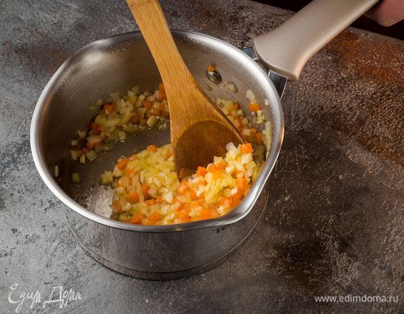В кастрюле с толстым дном разогреть оливковое масло. Лук обжарить на среднем огне до полупрозрачного состояния, добавить морковь, чеснок. Обжарить все вместе в течение 3 минут, помешивая.