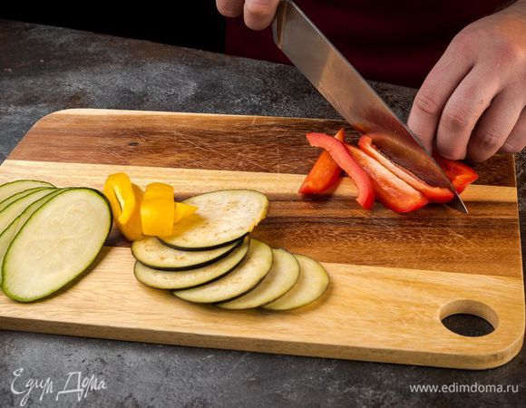 Баклажан и цукини нарезать вдоль тонкими пластинами. Сладкий перец, удалив плодоножку с семенами, нарезать крупными полосками.
