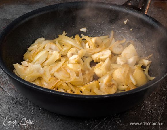 Нарезать лук и мелко порубить чеснок. Нарезать шампиньоны. Пожарить все на оливковом масле.
