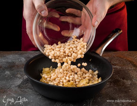 Добавить отваренную фасоль и воду. Томить на медленном огне 20 минут.