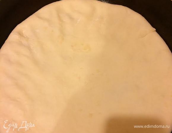 Аккуратно перенести лепешку на сковороду, положить швом вниз и руками распределить по сковороде.