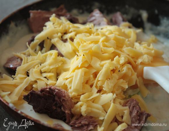 Снимите соус с огня, добавьте консервированного тунца (предварительно слейте жидкость) и натертый сыр. Перемешайте до однородности.