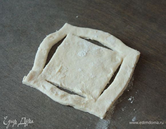 Раскатайте тесто в пласт толщиной 3 — 4 мм. Разрежьте пласт на одинаковые квадраты, из них мы будем делать лодочки. Внутри каждого квадрата сделайте два надреза буквой Г так, чтобы два противоположных угла были прорезаны полностью, а два других не до конца.