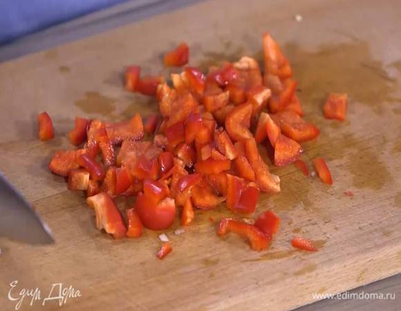 Сладкий перец, удалив плодоножку и семена, нарезать небольшими кусочками, выложить к луку и обжарить.