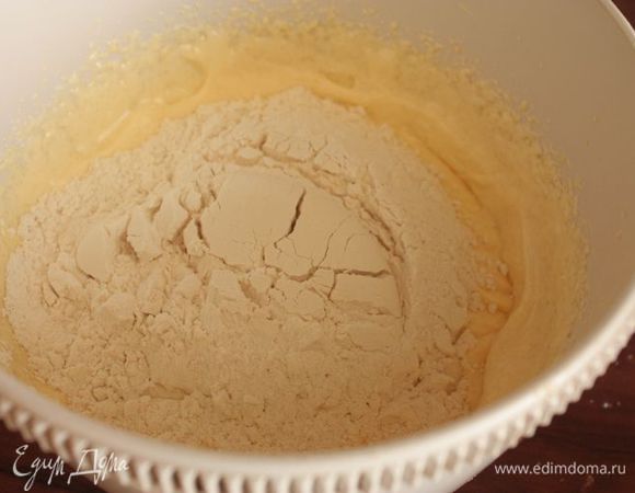 Всыпьте разрыхлитель теста и просеянную муку и замесите гладкое тесто.