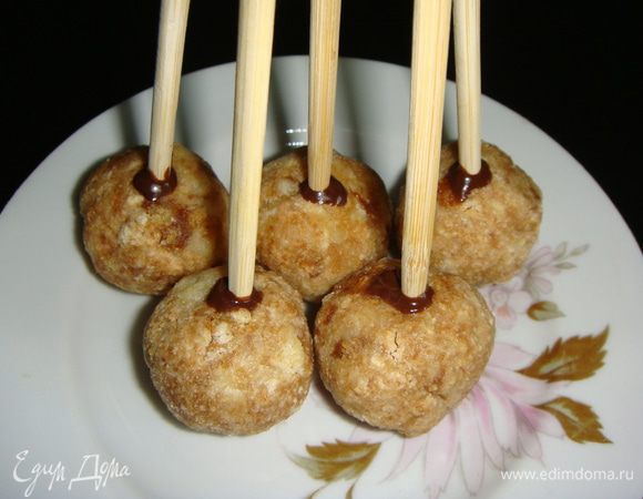 Берем палочки (для китайской еды или соломинки для коктейля), окунаем один край в шоколад на 0,5 см и вставляем в шарик. Убрать шарики в морозилку на 15 — 20 минут, чтобы шоколад застыл, и палочки крепко сидели в шариках.