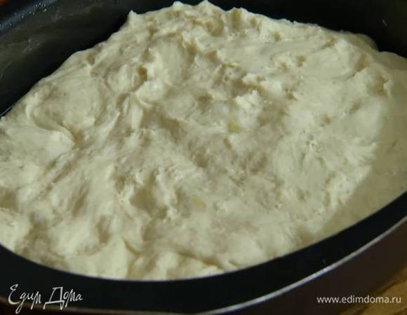 Подошедшее тесто обмять, выложить в глубокий овальный противень, смазанный оливковым маслом, и разровнять.