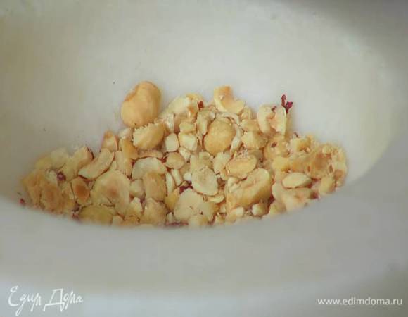 Фундук измельчить в ступке на небольшие кусочки.