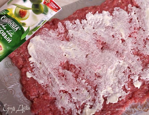 Духовку разогреваем до 200 град. На 2 листа фольги выкладываем фарш прямоугольником (толщина примерно 1 см) и смазываем мазонезом "Слобода оливковый"