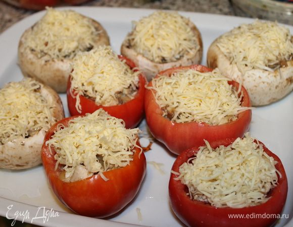 Сверху грибы и помидоры посыпать натертым твердым сыром и поставить в духовой шкаф при температуре 180°С примерно на 30 минут. Сыр должен зарумяниться. На порцию подавать по одному шампиньону и одному помидору. Украсить веточками свежей кинзы.