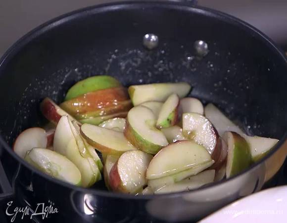 Разогреть в глубокой сковороде 2 ст. растопленного сливочного масла, выложить яблочные дольки, посыпать 2 ст. ложками сахара и дать закарамелизироваться.