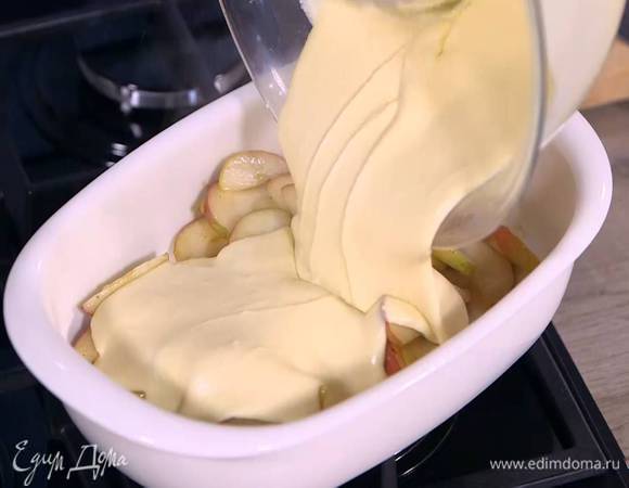 В жаропрочную керамическую форму выложить яблоки вместе с соусом и залить тестом.