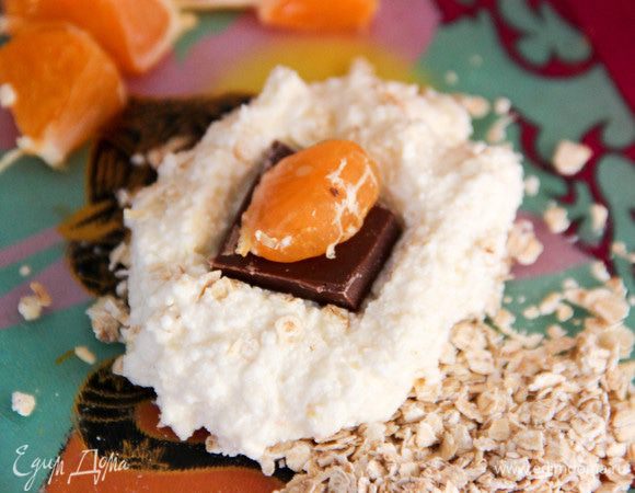 Чтобы сырники лепились лучше, рекомендую оставить творожную массу минут на 10. Ложкой отделяем кусочек массы, формируем лепешку. В середину кладем кусочек шоколадки и половинку дольки мандарина. Защипываем края, формируя сырник.