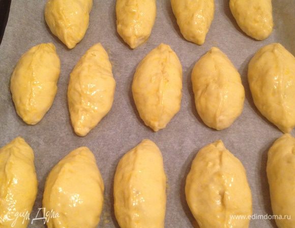 Выложите булочки на застеленный бумагой для выпечки противень, смажьте их слегка взбитым яйцом и дайте расстояться немного (пока нагревается духовка).