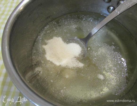 В сотейник влить воду, 150 мл персикового сиропа. Поставить на огонь и подогреть. В горячей массе распустить желатин. Размешать до растворения желатина. Дать остыть примерно до 30°С.